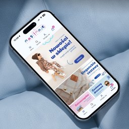 Sellflow Sp. z o.o. - Smartfon wyświetla stronę sklepu internetowego z odzieżą dziecięcą na tle niebieskiej, teksturowanej powierzchni. Widoczne menu, kategorie produktów i logo sklepu.