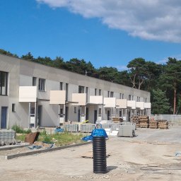 Elewent Krzysztof Kawala- Elewację wentylowane - Nowoczesny budynek wielorodzinny w trakcie budowy, widoczne ocieplone elewacje, balkony, materiały budowlane i elementy infrastruktury podziemnej.