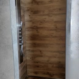 Przemysław Rolnik - Nowoczesna kabina prysznicowa z panelem natryskowym ze stali nierdzewnej i drewnopodobną okładziną ścienną i podłogową, zrealizowana w Żarnowie.