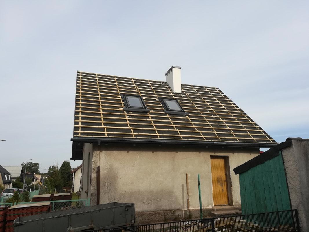 Dom jednorodzinny w trakcie układania łat dachowych i montażu okien dachowych na czarnej membranie dachowej.