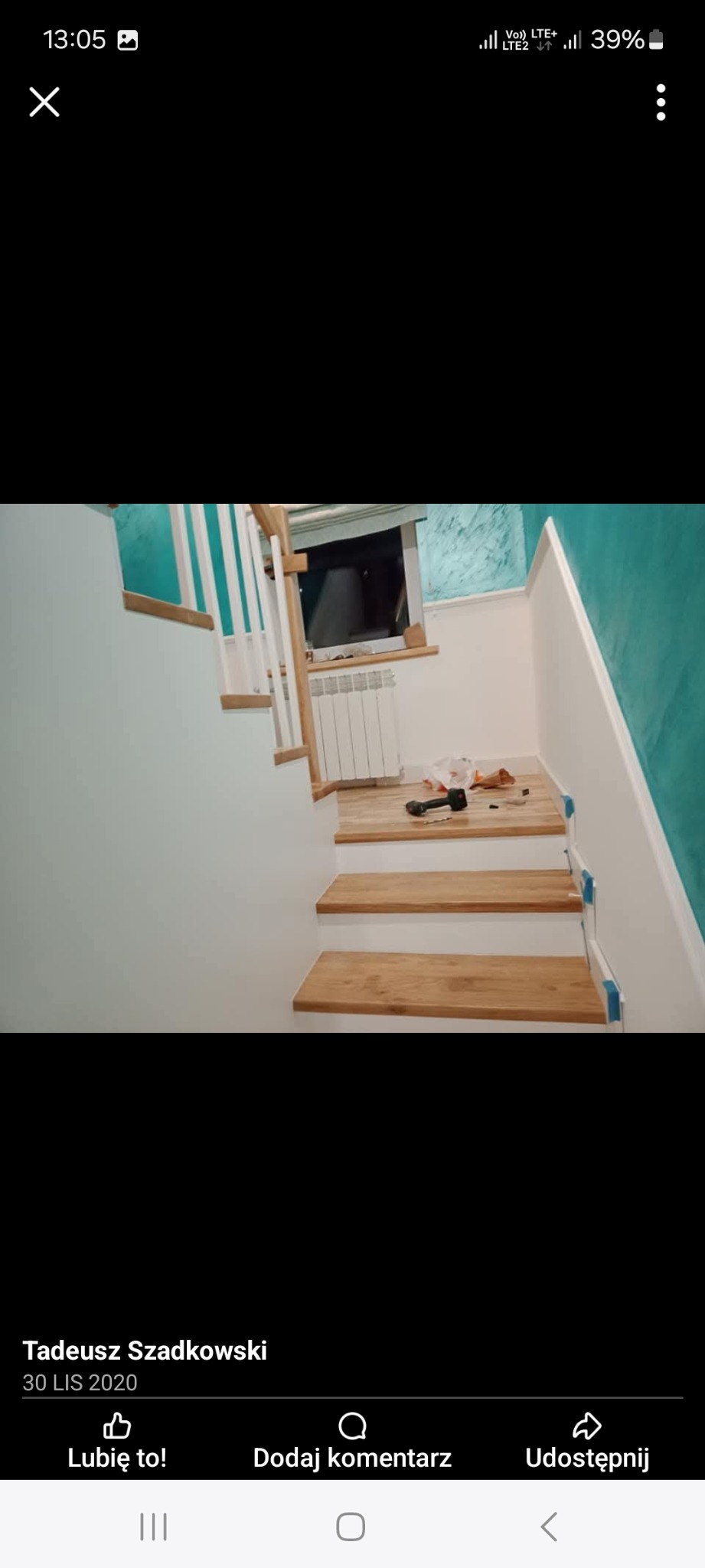 Montaż drewnianych stopni schodowych wewnątrz budynku, widoczne narzędzia i akcesoria montażowe, ściana pomalowana na biało i turkusowo, częściowo zamontowana balustrada.