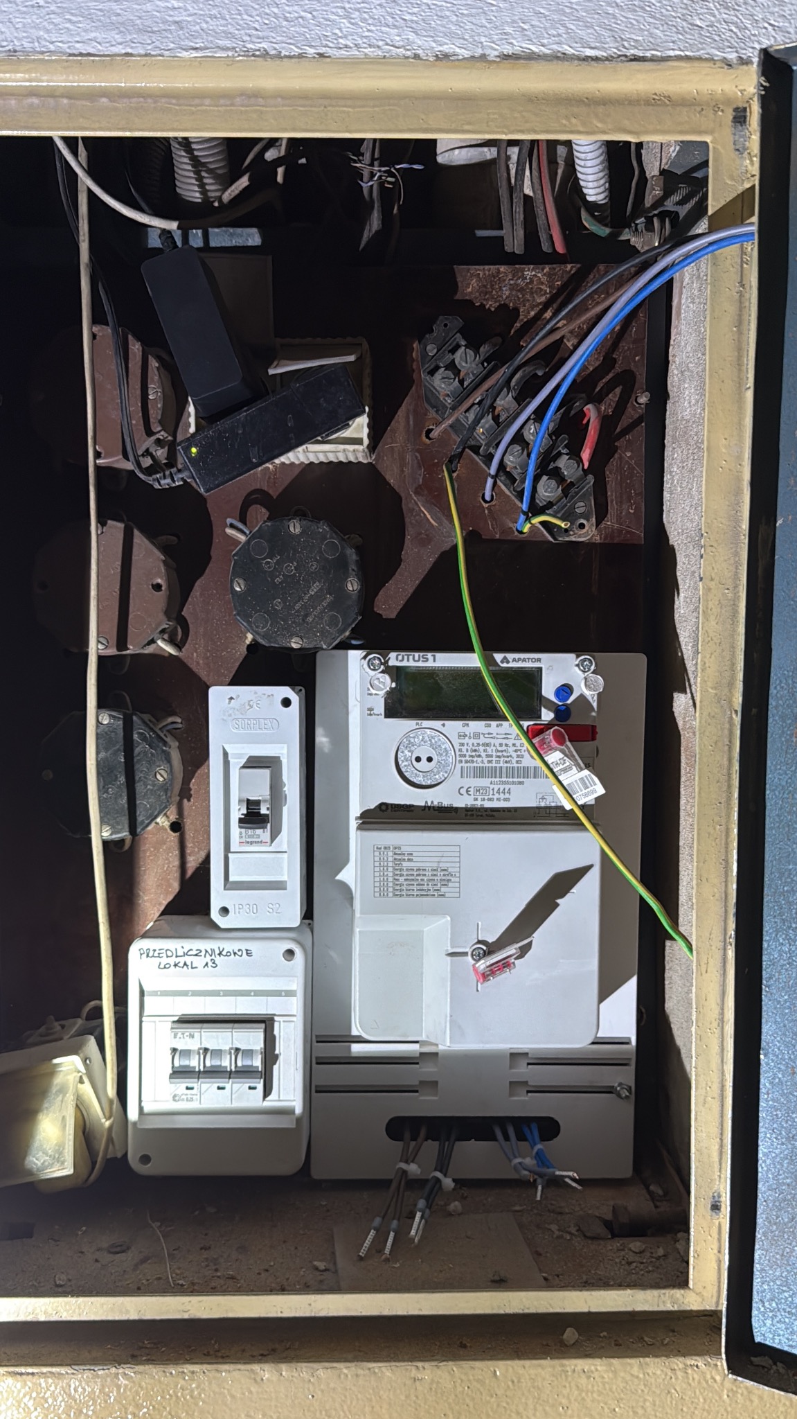 Przebudowana rozdzielnia elektryczna w bloku z licznikiem i zabezpieczeniami, przygotowana do podłączenia trójfazowego zasilania dla płyty indukcyjnej.