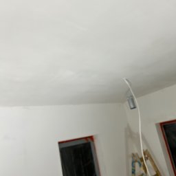 Colorview - Wnętrze w trakcie remontu: świeżo wykończona, biała sufit z widocznymi śladami szpachlowania, drabina oparta o ścianę, okna zabezpieczone folią.