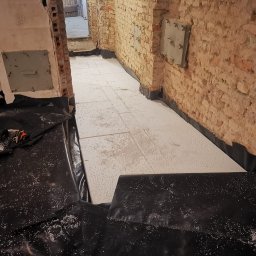 Renowacja starej podłogi. Czarna folia budowlana jako hydroizolacja, a styropian EPS jako ocieplenie.