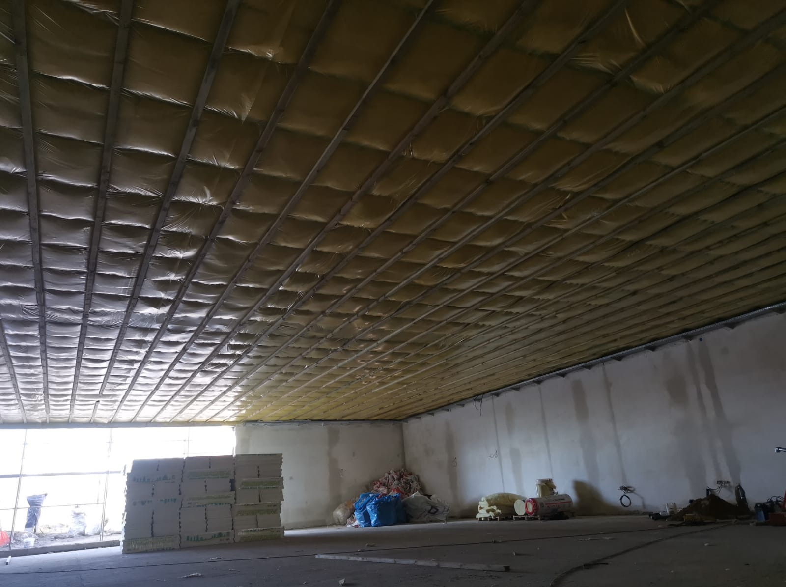 Szkielet sufitu podwieszanego. Paroizolacja i długie łaty.