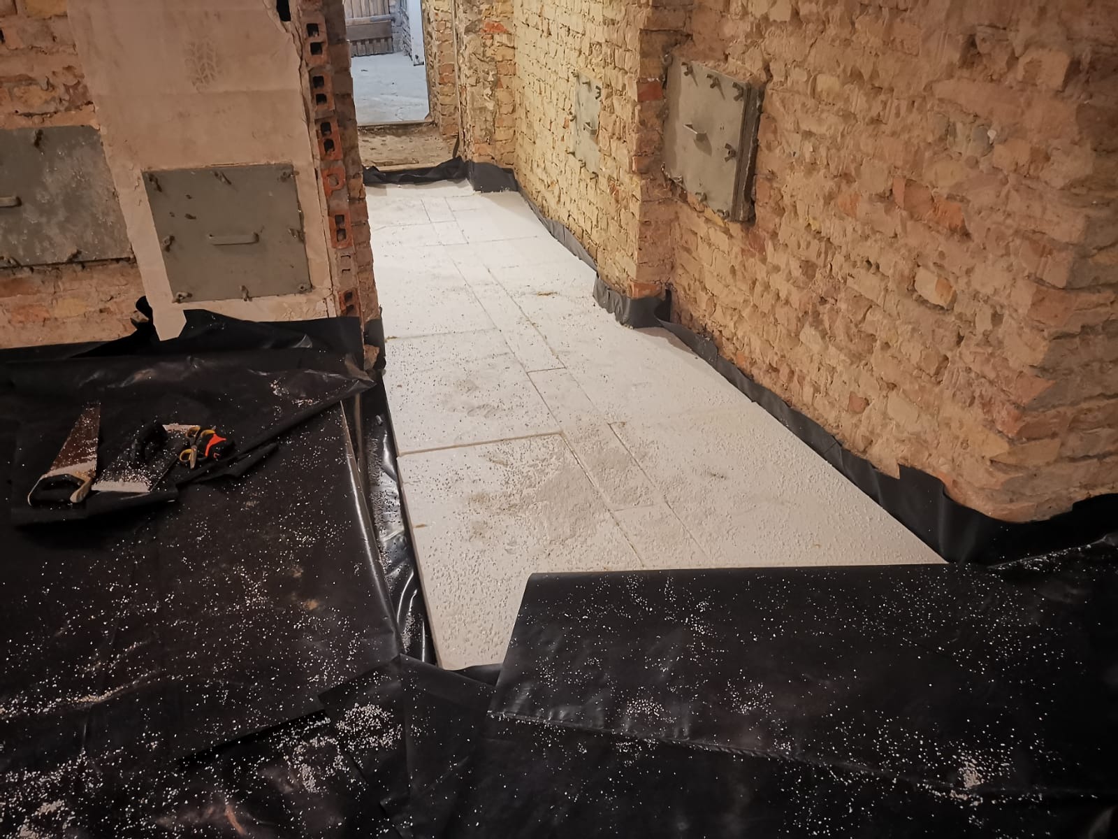 Renowacja starej podłogi. Czarna folia budowlana jako hydroizolacja, a styropian EPS jako ocieplenie.