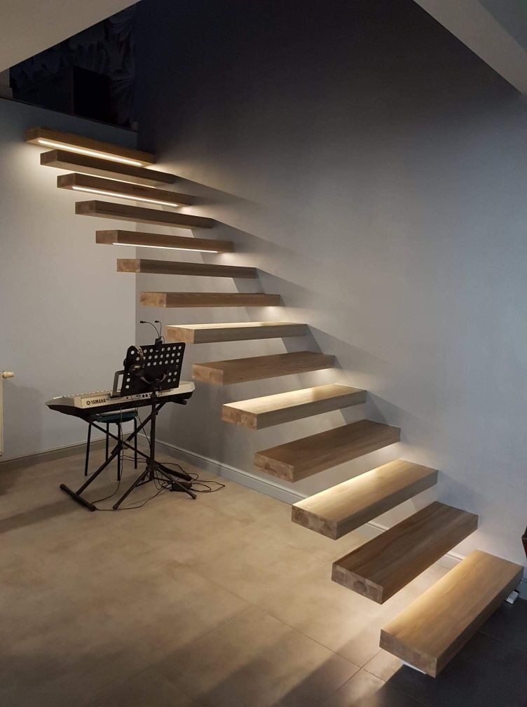 Nowoczesne schody drewniane wspornikowe z podświetleniem LED, obok pianino Yamaha i pulpit na nuty.