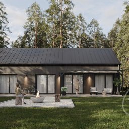 Skandic Hus - Czarny dom szkieletowy z płaskim dachem, z oknami przesuwnymi, oświetleniem zewnętrznym i strefą relaksu z paleniskiem na zewnątrz, otoczony wysokimi drzewami.