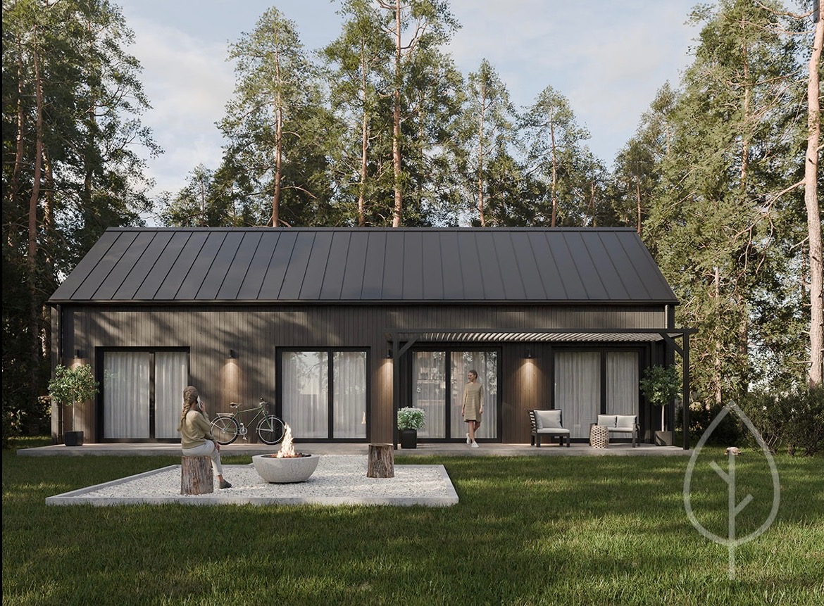 Czarny dom szkieletowy z płaskim dachem, z oknami przesuwnymi, oświetleniem zewnętrznym i strefą relaksu z paleniskiem na zewnątrz, otoczony wysokimi drzewami.