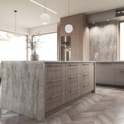 AW studio - Nowoczesna kuchnia z wyspą i parkietem w jodełkę. Marmurowy blat wyspy kuchennej, minimalistyczne oświetlenie i stonowana kolorystyka tworzą elegancką przestrzeń.