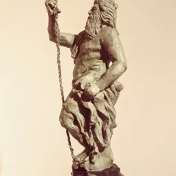 Gliniasta statuetka Posejdona z trójzębem, na cokole z motywami morskimi, w ciepłej tonacji. Widoczny podpis autora: A. Wolska.