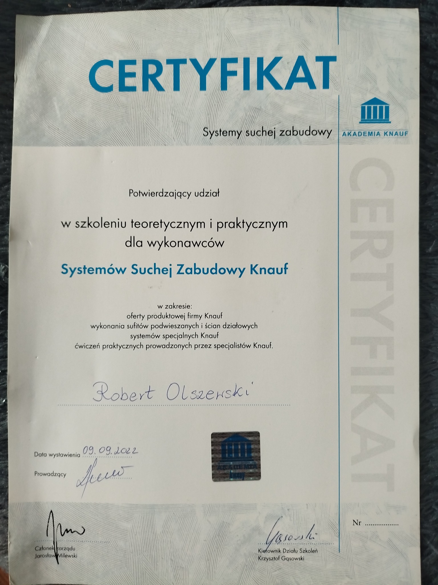 Skan certyfikatu Akademii Knauf potwierdzający udział w szkoleniu teoretycznym i praktycznym z zakresu systemów suchej zabudowy, z widocznym podpisem Roberta Olszewskiego i datą wystawienia 09.09.