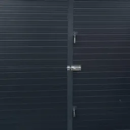 Szara, poziomo żłobkowana brama garażowa z zamkiem na klucz, widoczna z bliska, z fragmentem rynny w tle.