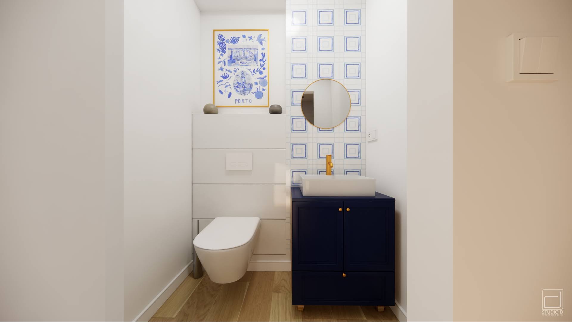 Kompaktowa łazienka z toaletą w zabudowie, umywalką na szafce w kolorze granatowym ze złotymi akcentami, okrągłym lustrem i dekoracyjną grafiką w stylu portugalskim.