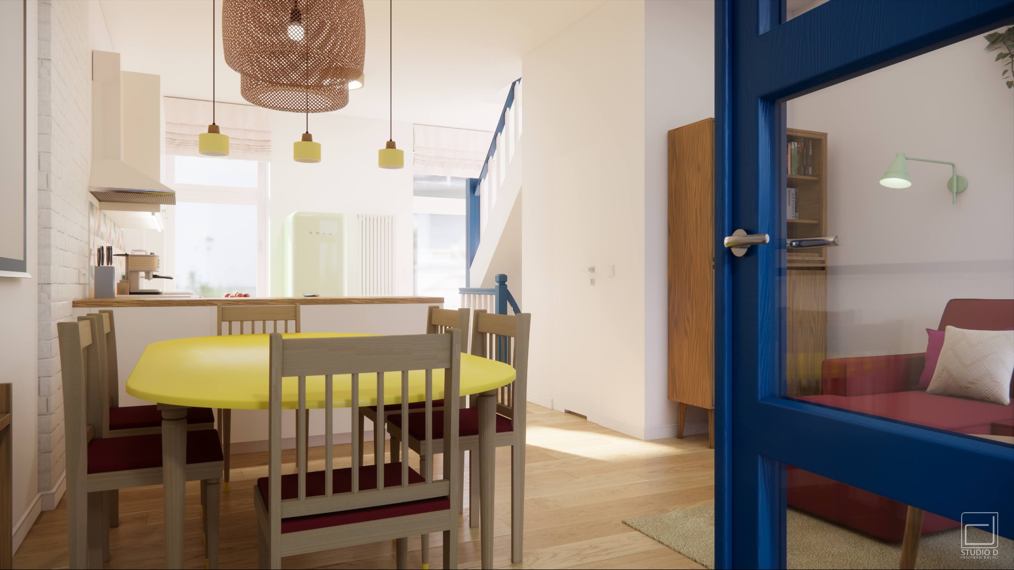 Jasne wnętrze mieszkania z żółtym okrągłym stołem i krzesłami, widok przez niebieskie drzwi na salon z czerwoną sofą, w tle kuchnia z pastelową lodówką i schody.