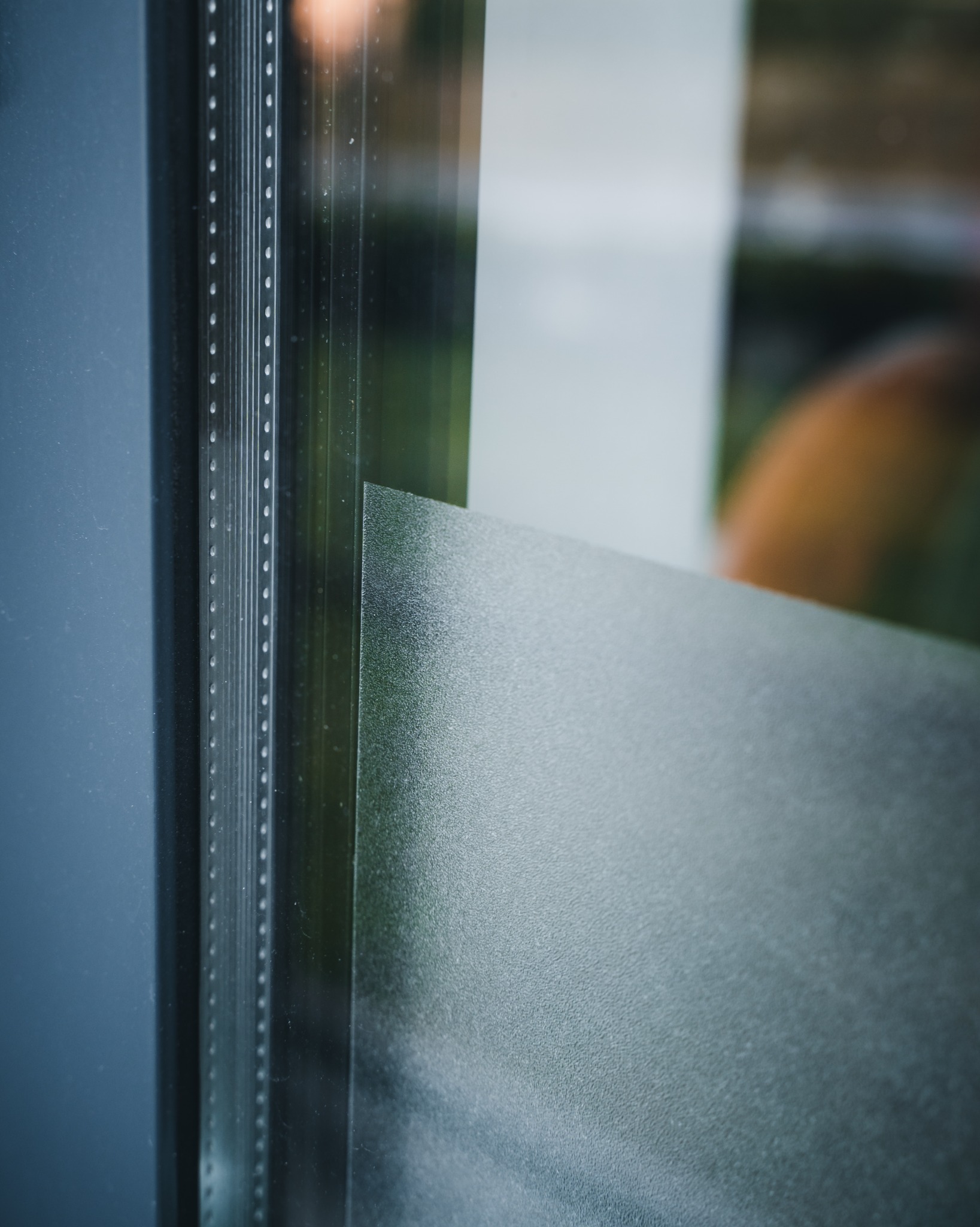 Detale okna z folią matującą, widoczne listwy i struktura powierzchni szkła.