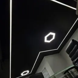 Czarne podwieszane wnętrze biura z geometrycznymi liniami oświetlenia LED, widok z dołu na szklany stół i krzesła biurowe