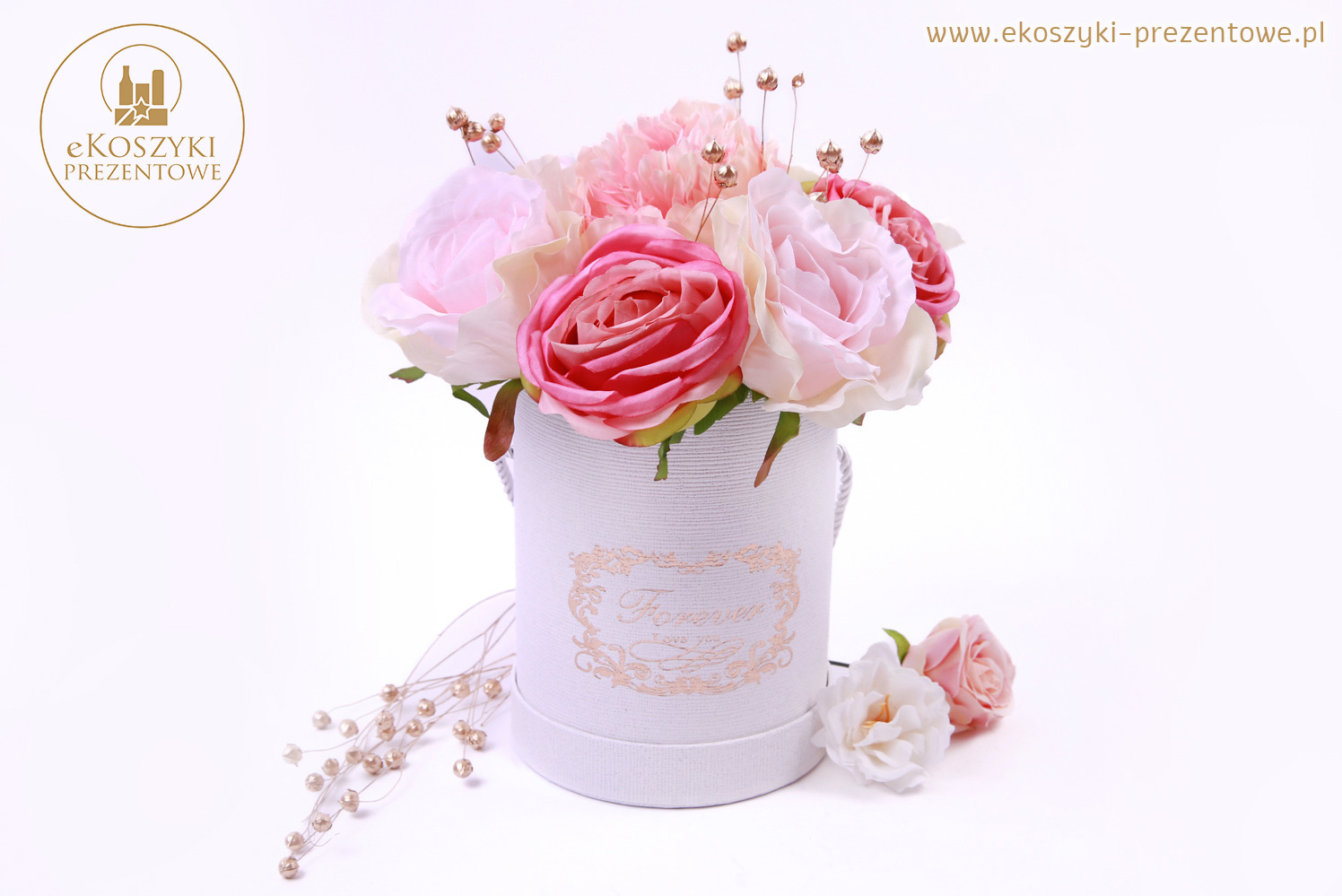 Kompozycja kwiatowa w białym pudełku z napisem 'Forever' i złotymi akcentami, uzupełniona o perłowe dekoracje, na jasnym tle. Romantyczny upominek.