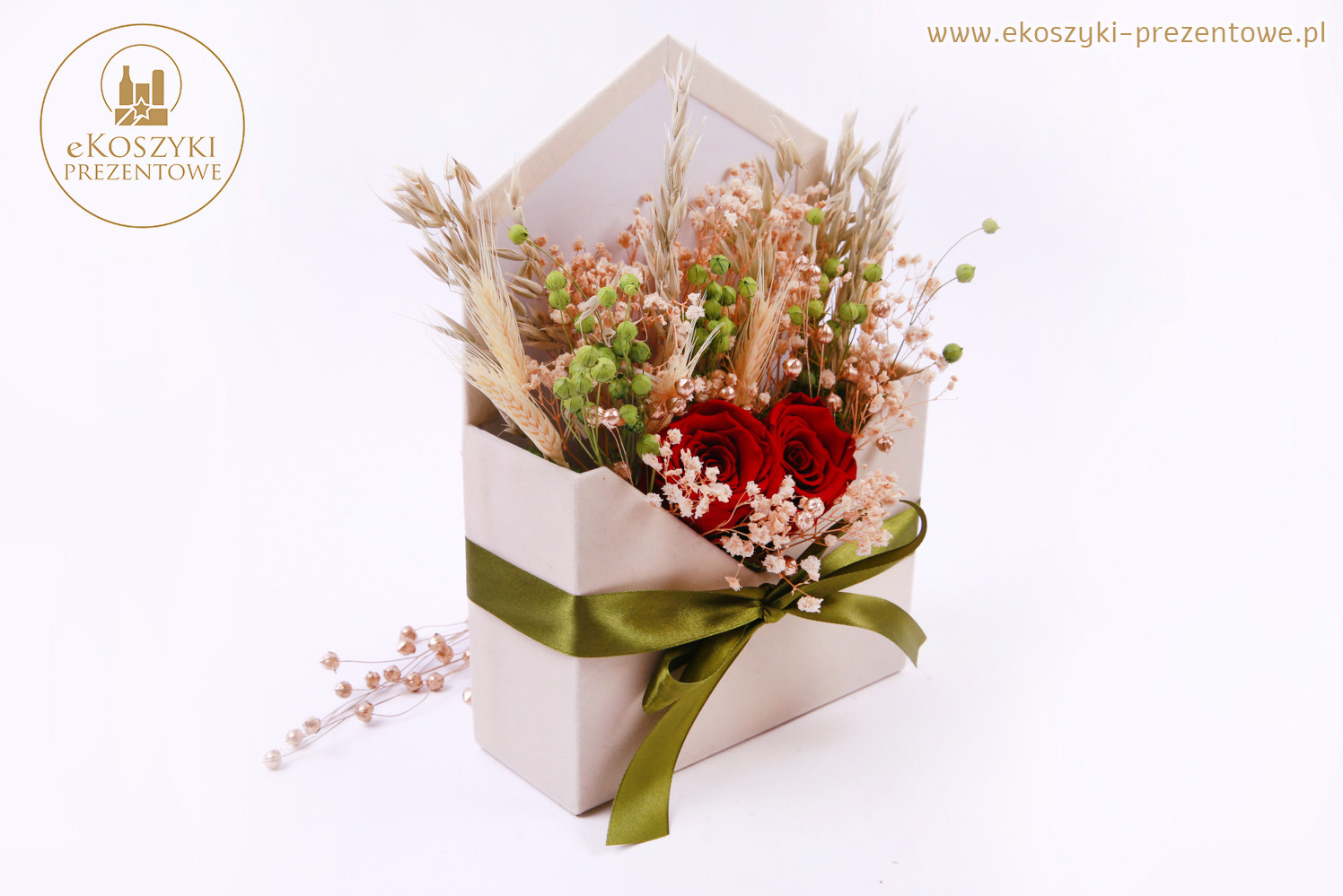 Kompozycja kwiatowa w pudełku w kształcie koperty, z czerwoną różą, zieloną wstążką i elementami suszu. Minimalistyczne tło, stonowana kolorystyka.