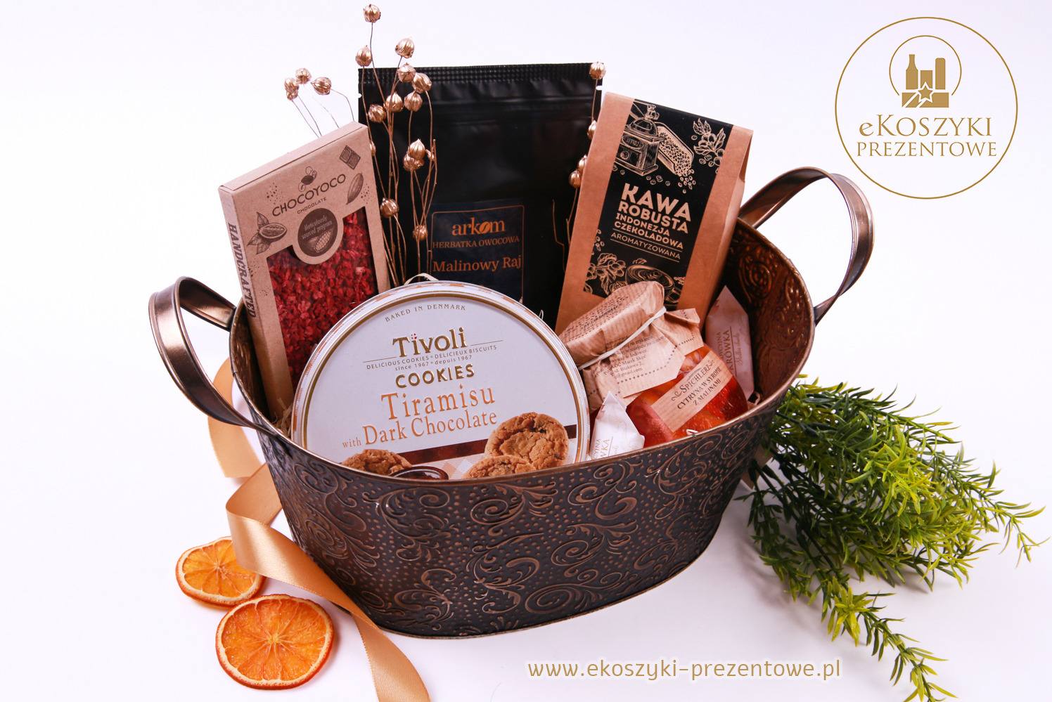 Elegancki, ręcznie robiony kosz z kawą, herbatą, ciasteczkami i suszonymi pomarańczami, ozdobiony złotą wstążką, idealny na prezent.
