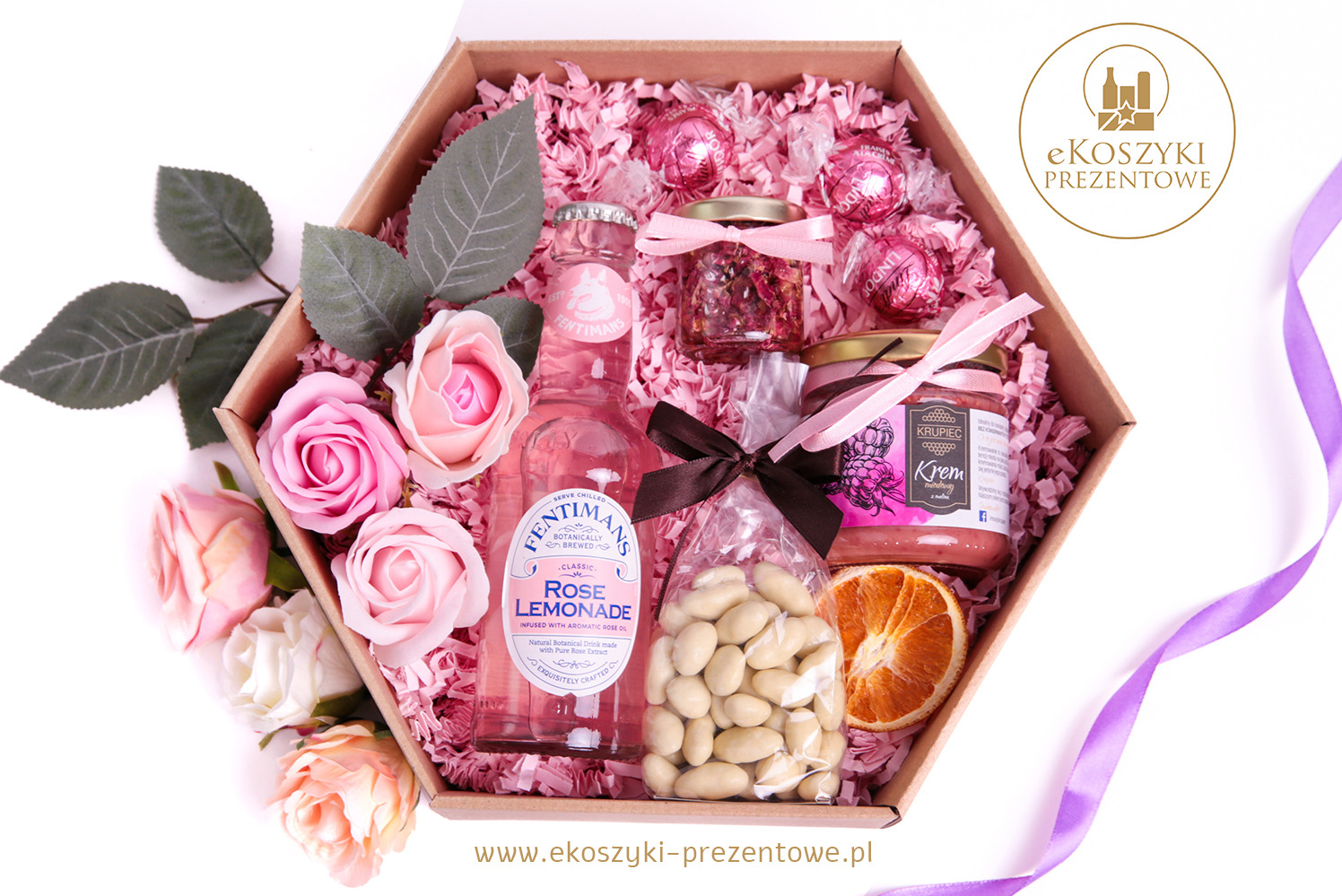 Różowy zestaw upominkowy w heksagonalnym pudełku: napój różany, krem, słodycze Lindor, migdały, suszona pomarańcza, róże. Romantyczny upominek.