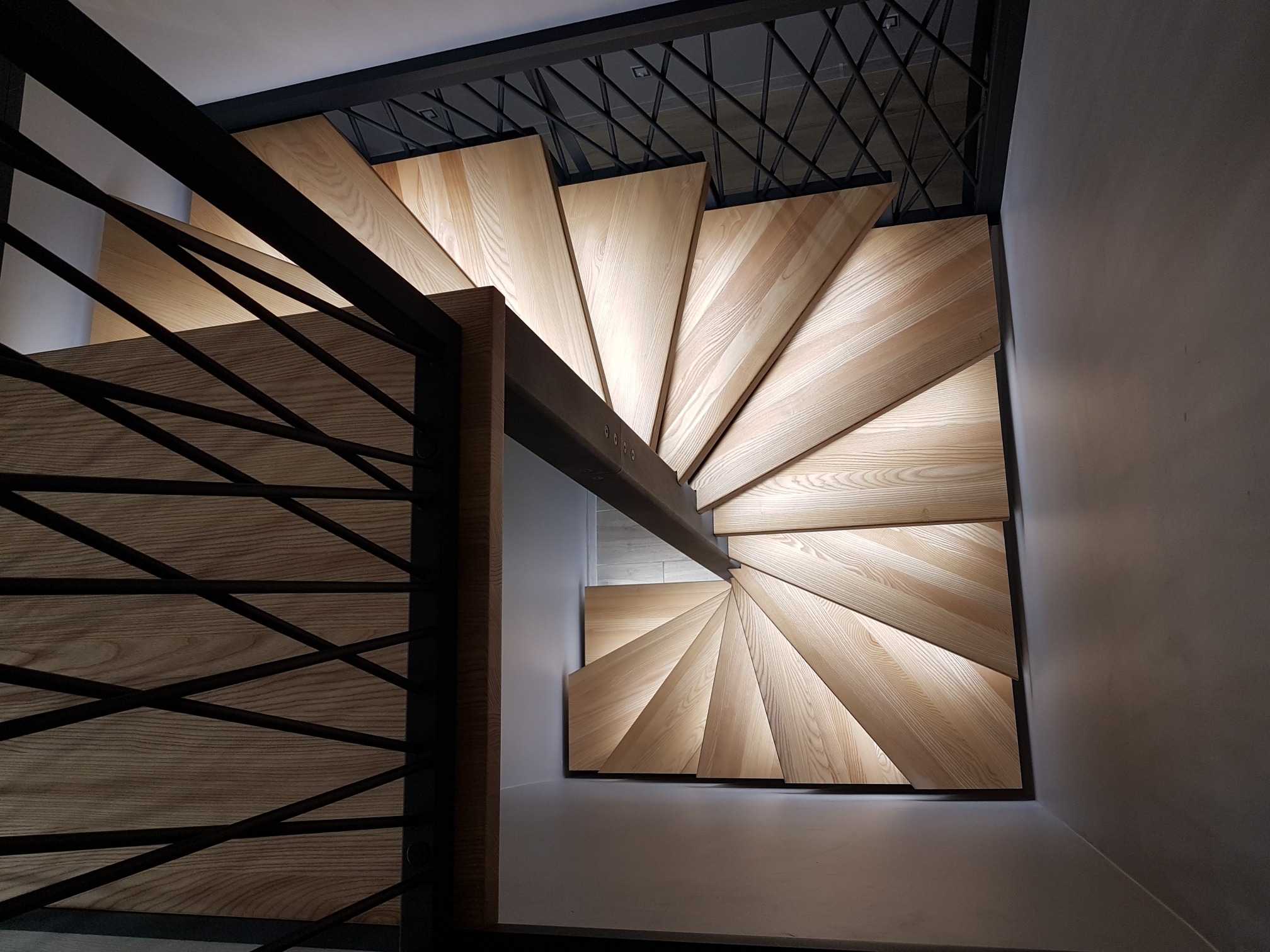 Schody jesionowe kręte na konstrukcji metalowej