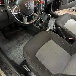 AlwaysClean Myjnia Samochodowa - odbiór i dowóz auta Łódź - Wnętrze samochodu Dacia Duster: kierownica z logo, dwukolorowe fotele z jasnoszarą wstawką, gumowe dywaniki z wytłoczeniami.