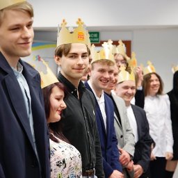 Uslugi fotograficzne - Grupa młodych ludzi w koronach Burger King ustawiona w rzędzie, uśmiechnięta, w formalnych strojach, prawdopodobnie podczas wydarzenia firmowego lub uroczystości.