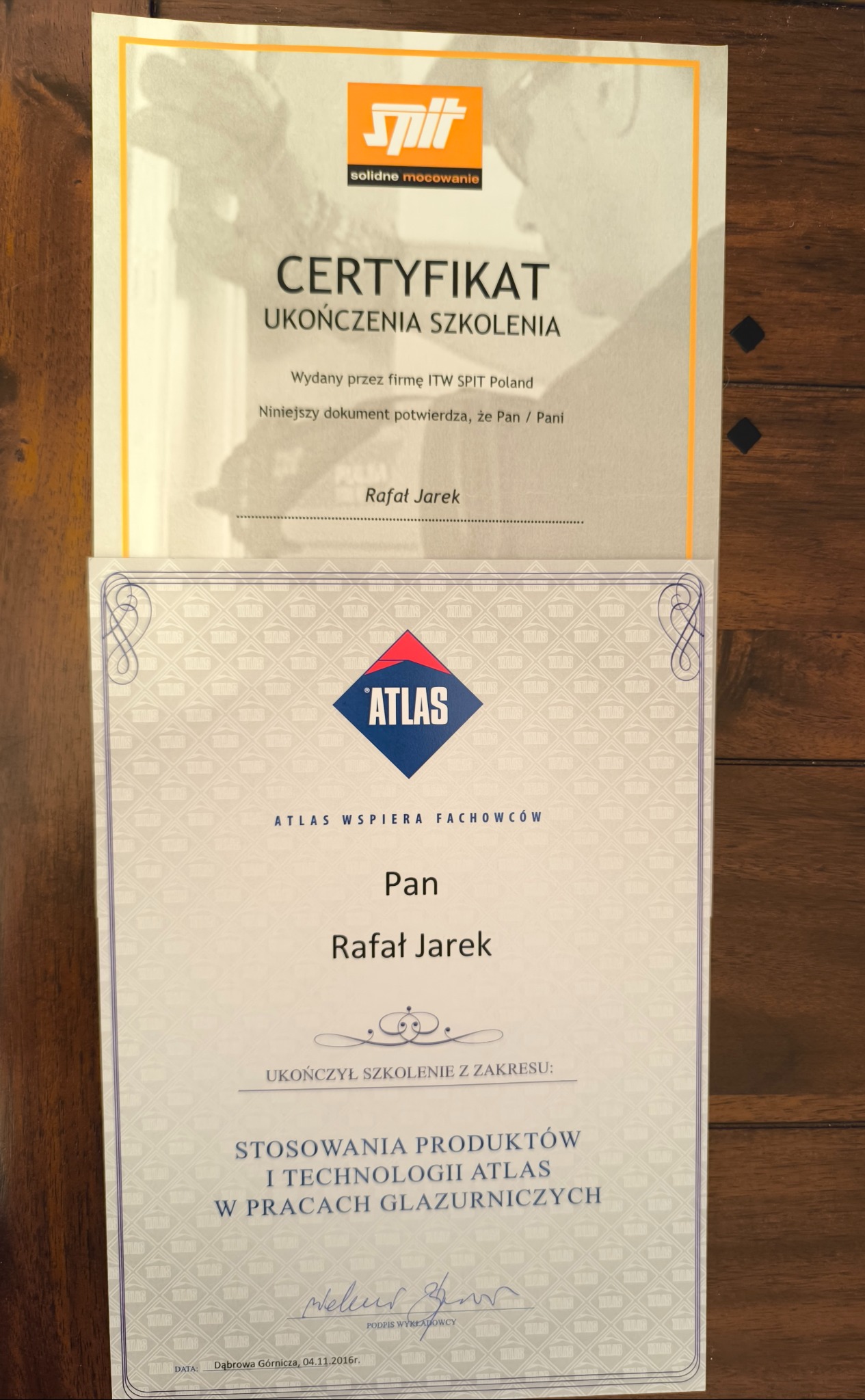 Dwa certyfikaty ukończenia szkolenia, jeden od firmy ITW SPIT Poland, drugi od firmy Atlas, oba dla Rafała Jarka, dotyczące stosowania produktów i technologii Atlas w pracach glazurniczych.