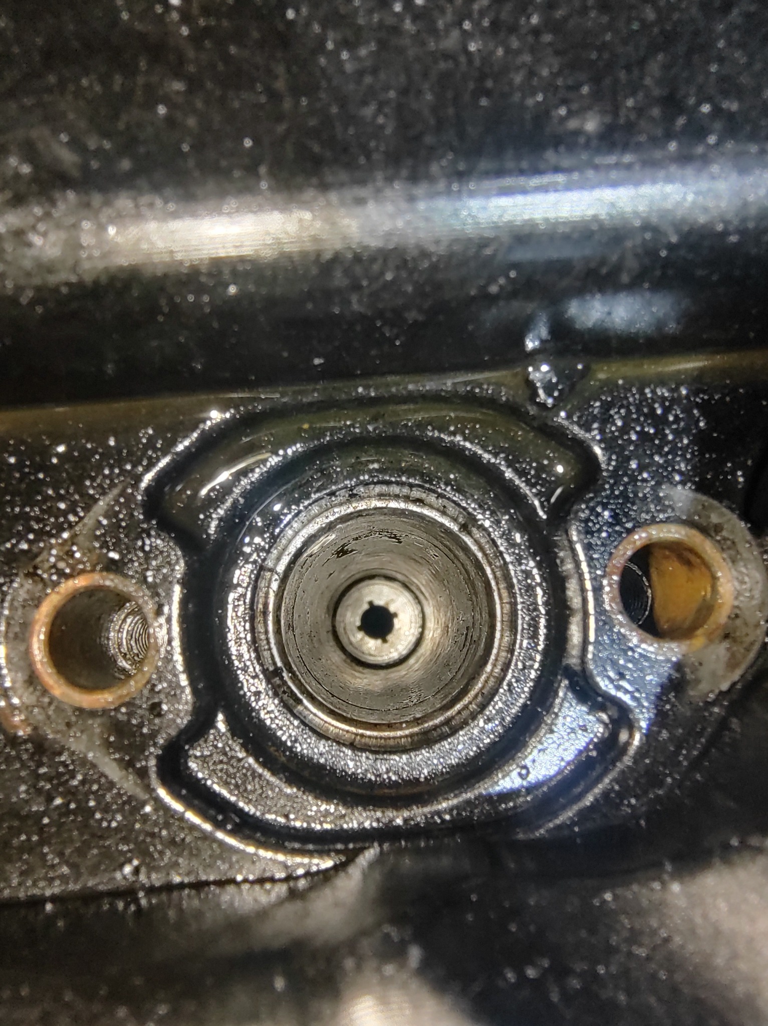 Olej silnikowy w cylindrze silnika spalinowego w Cząstkowie. Widoczne ślady zużycia i nagaru. Detal z bliska, ukazujący wnętrze silnika.