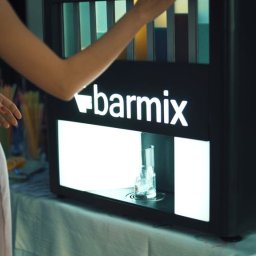 EventMagic - Obsługa automatycznego dystrybutora drinków 'barmix' podczas imprezy, widoczny szklanka z lodem w podświetlanej wnęce.