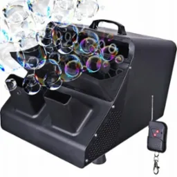 Czarna maszyna do baniek mydlanych z pilotem, wytwarzająca liczne tęczowe bańki w powietrzu.