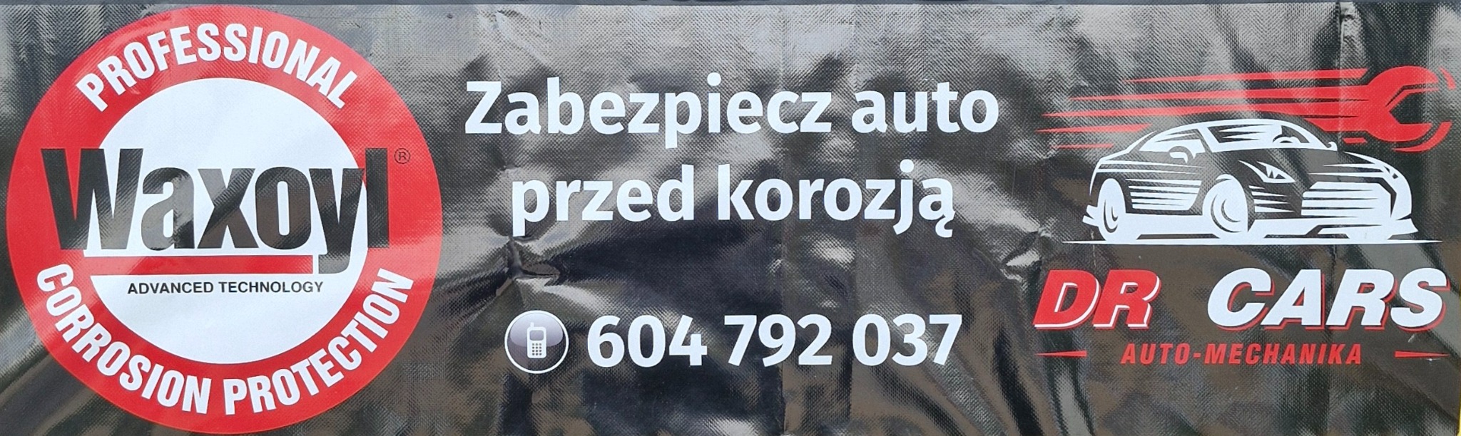 Baner reklamowy z napisem: Zabezpiecz auto przed korozją, logo Waxoyl, numer telefonu i logo DR Cars Auto-Mechanika na czarnym, teksturowanym tle.