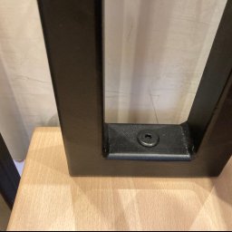 Geso Steel - Detal metalowej nogi stołu z widocznym mocowaniem do drewnianego blatu, spawane łączenie, czarna farba proszkowa.