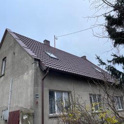 Dachy Twardysko - Dom jednorodzinny z ciemnobrązowym dachem z dachówki, widoczne okna dachowe, rynny i numer posesji '30'.