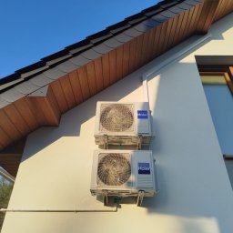 MK KLIMWENT SPÓŁKA Z OGRANICZONĄ ODPOWIEDZIALNOŚCIĄ - Dwa klimatyzatory Haier zamontowane jeden nad drugim na elewacji domu w Gdańsku, widoczne elementy dachu i okno.