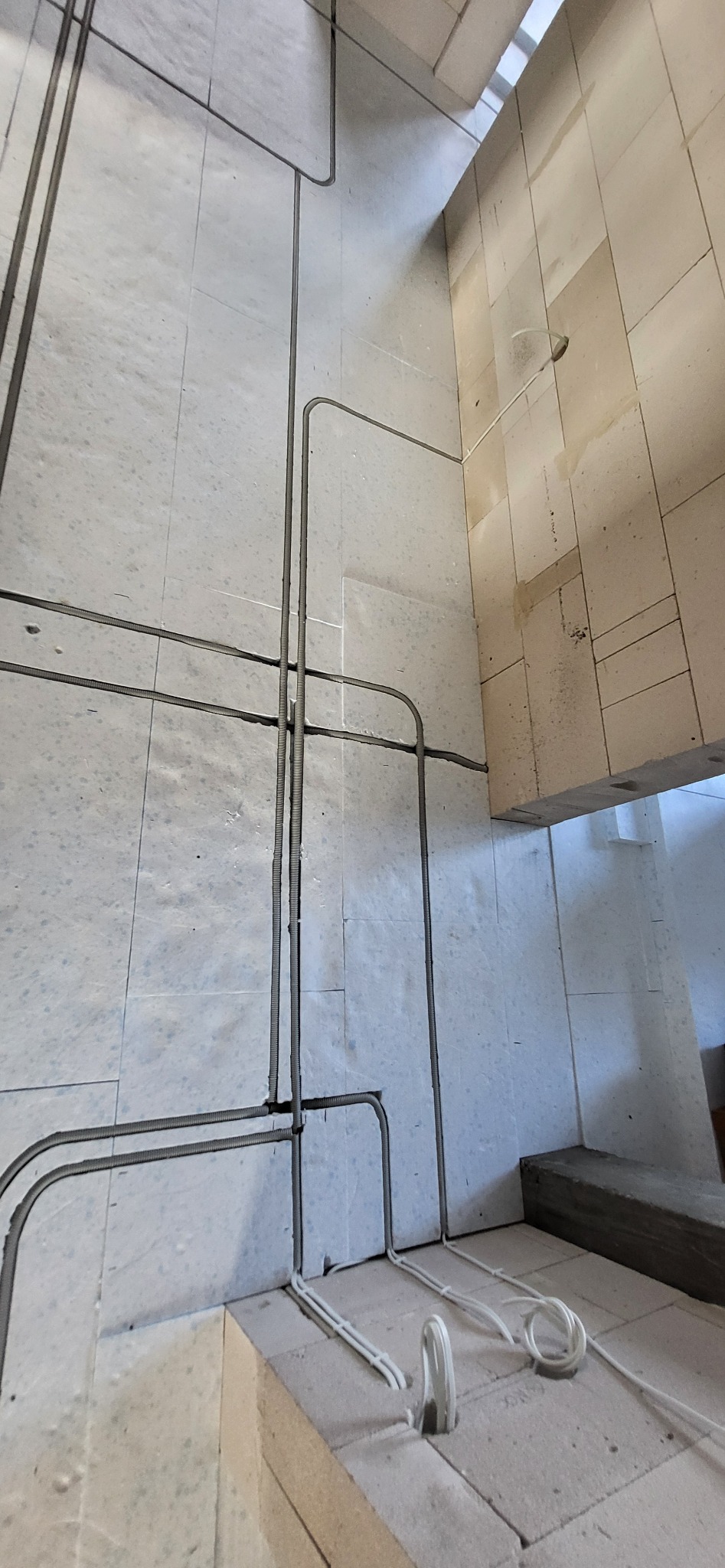 Instalacja elektryczna w peszlach na ścianach i podłodze z pustaków ceramicznych.