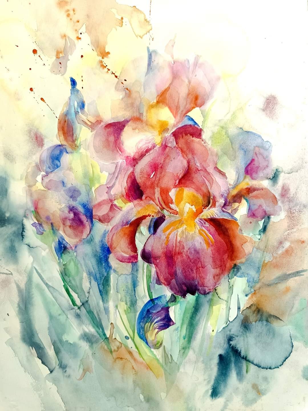 Abstrakcyjna akwarela przedstawiająca bukiet irysów w odcieniach różu, fioletu, żółci i zieleni, z delikatnymi plamkami i rozpryskami farby na jasnym tle.
