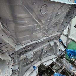 EMTE-SERWIS - Podwozie samochodu po zabezpieczeniu antykorozyjnym, widoczne elementy konstrukcyjne pokryte srebrzystą powłoką ochronną, zabezpieczone elementy osprzętu w niebieskiej folii.