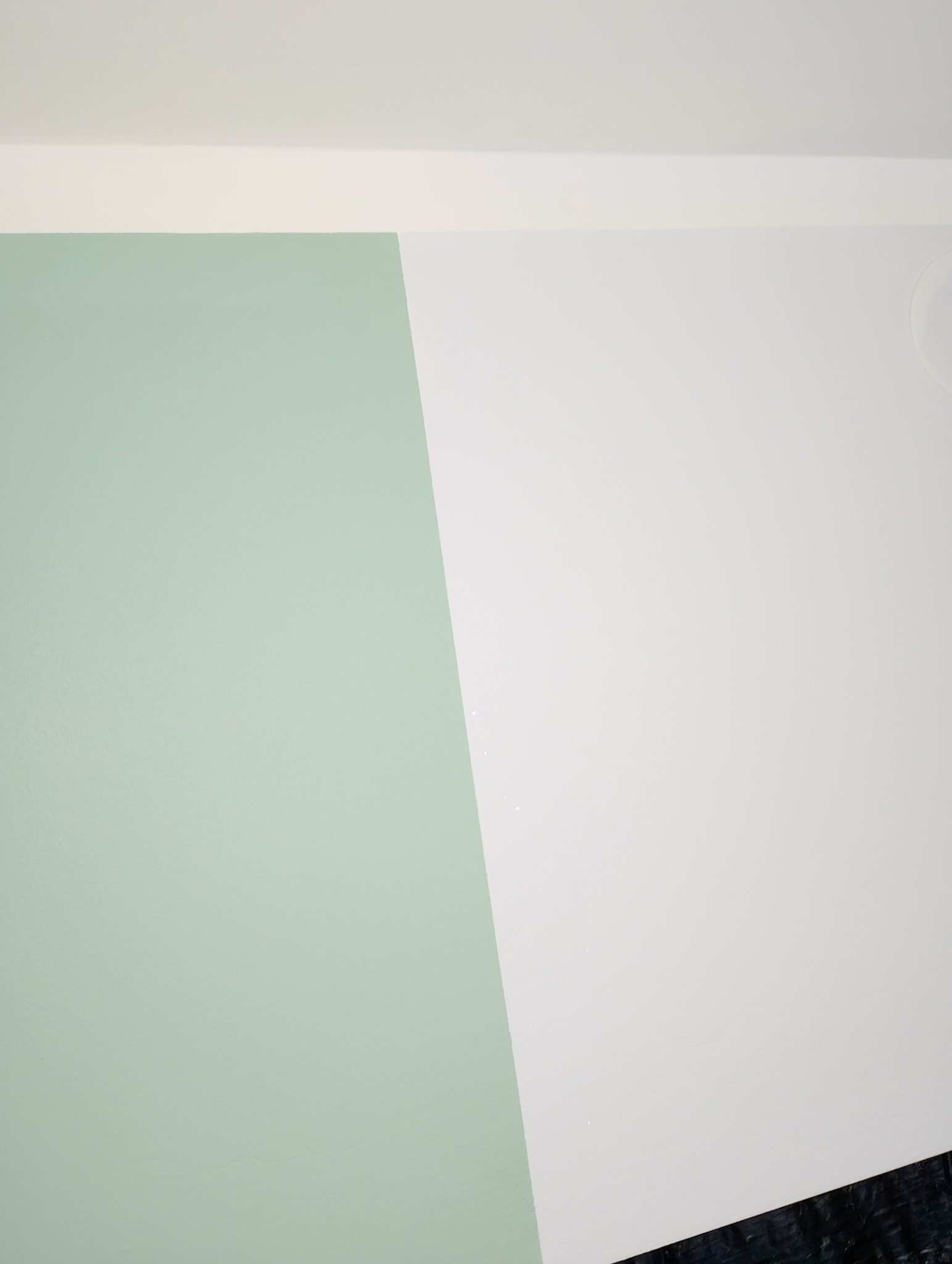 Ściana wewnętrzna pomalowana na dwa kolory: miętowy i biały, z widocznym fragmentem sufitu i podłogi.