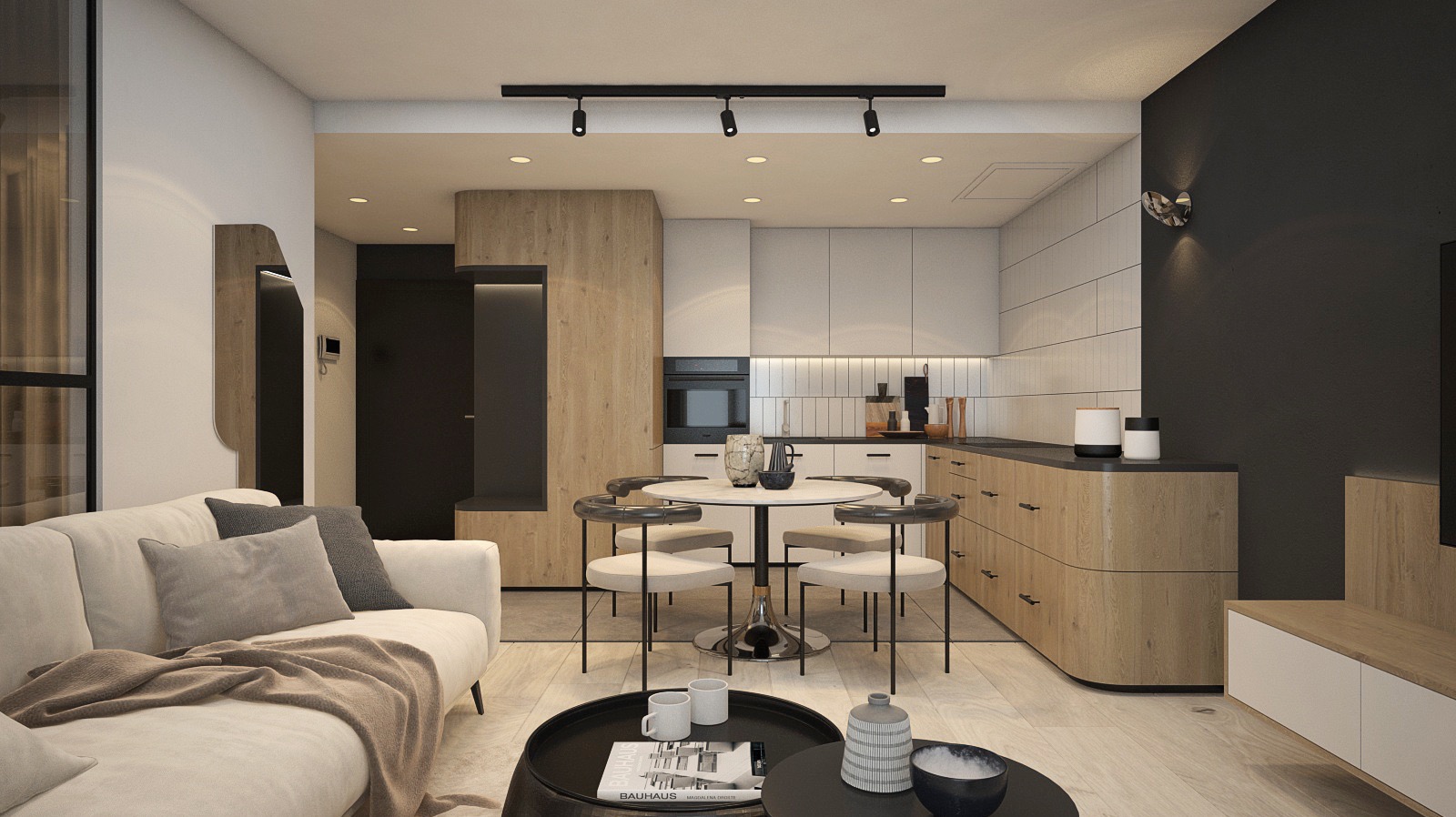 Nowoczesne wnętrze mieszkania z otwartą kuchnią, beżowa sofa z poduszkami, okrągły stół jadalny z krzesłami, czarny stolik kawowy z książkami i dekoracjami, oświetlenie punktowe na suficie.