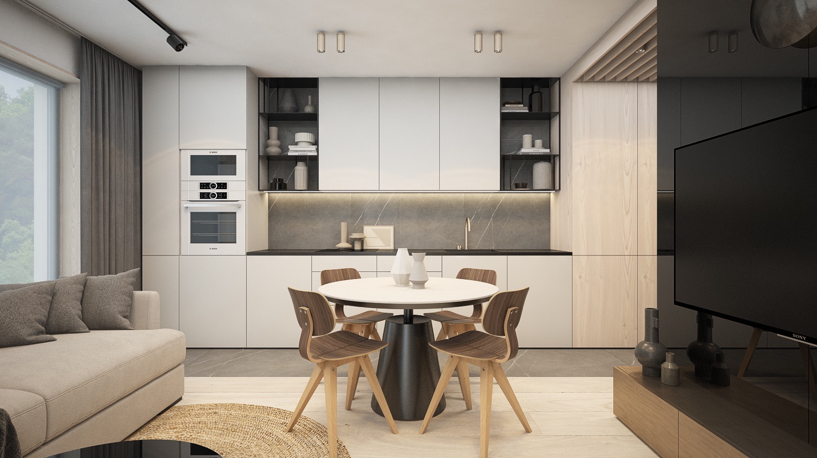 Wnętrze mieszkania w minimalistycznym stylu: biała zabudowa kuchenna z czarnymi akcentami, okrągły stół z drewnianymi krzesłami, szara sofa i duży telewizor.