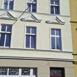 LIS-BUD BARTŁOMIEJ LISIECKI - Fasada kamienicy z oknami po renowacji, widoczne detale architektoniczne i odświeżona kolorystyka elewacji sąsiadujących budynków