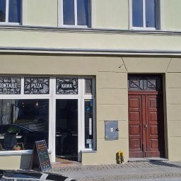 LIS-BUD BARTŁOMIEJ LISIECKI - Zewnętrzny widok odnowionej elewacji budynku z restauracją, z oknami z białymi ramami i dekoracyjnymi elementami nad oknami, widoczny fragment czarnego samochodu na pierwszym planie, kostka brukowa...