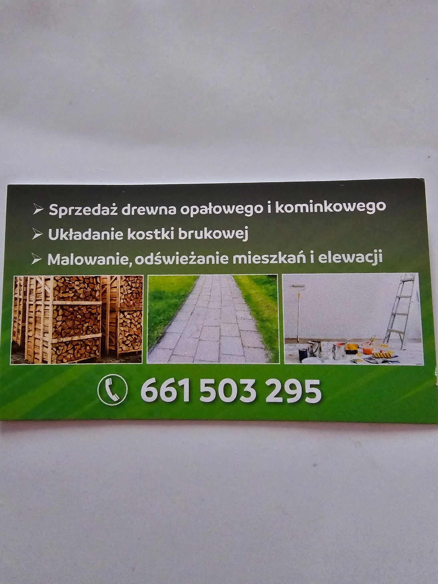 Wizytówka firmy oferującej sprzedaż drewna, układanie kostki brukowej oraz malowanie mieszkań i elewacji. Na wizytówce zdjęcia drewna, kostki brukowej i akcesoriów malarskich.