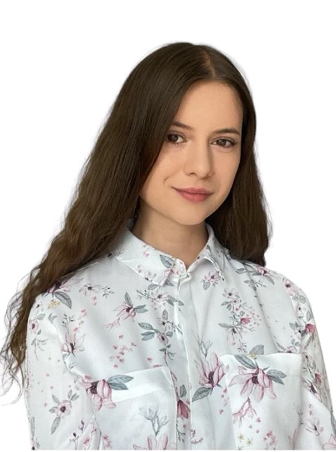 Portret uśmiechniętej kobiety z długimi brązowymi włosami, ubrana w białą koszulę w kwiaty na białym tle.