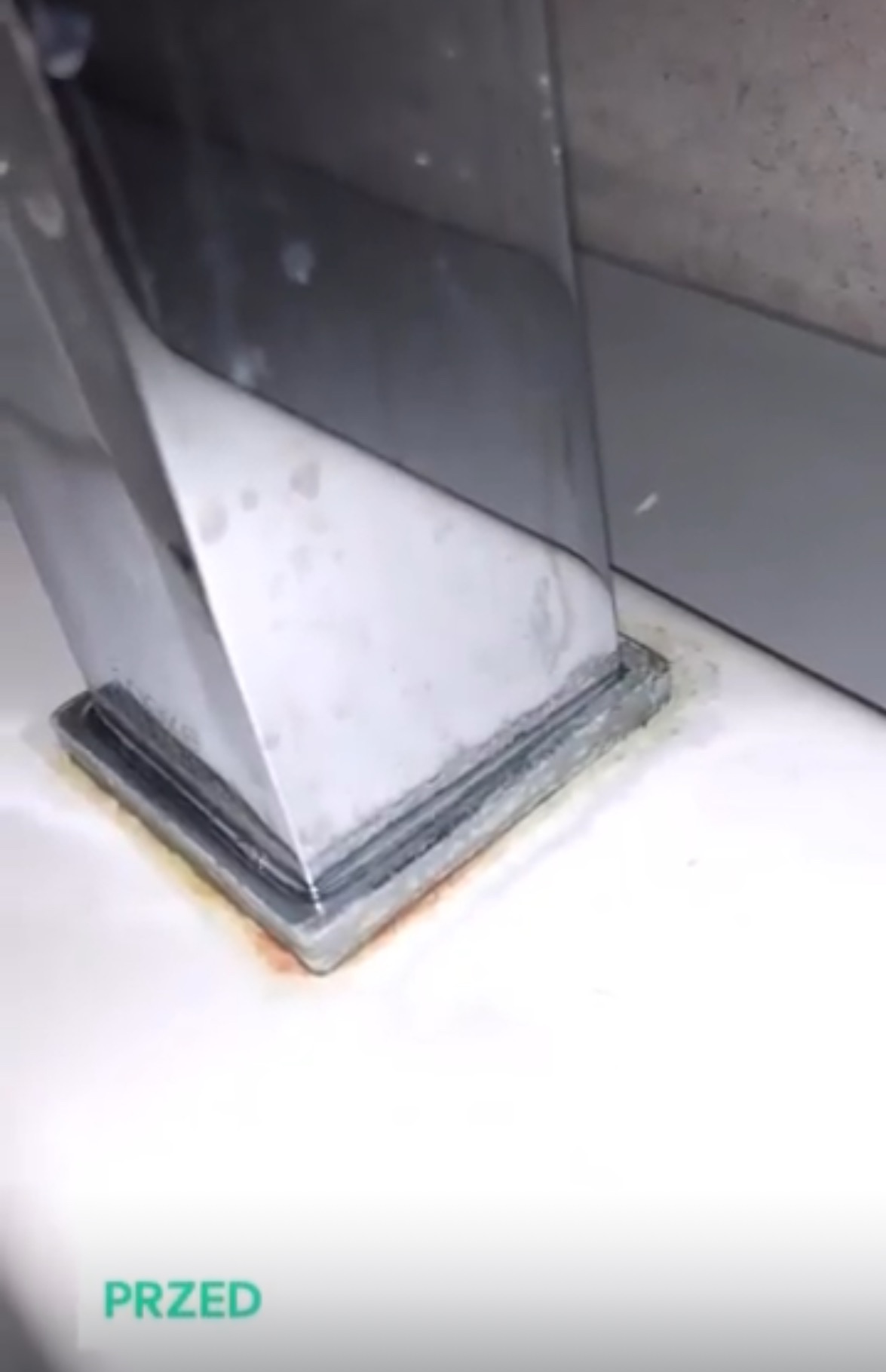 Zacieki i osad na podstawie chromowanej armatury łazienkowej, widoczne ślady rdzy i kamienia przed czyszczeniem.