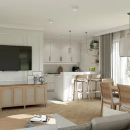 Jasne, przestronne wnętrze domu z otwartą kuchnią, jadalnią i salonem. Widoczny duży telewizor na ścianie z dekoracyjną sztukaterią, drewniana podłoga w jodełkę i nowoczesne oświetlenie.