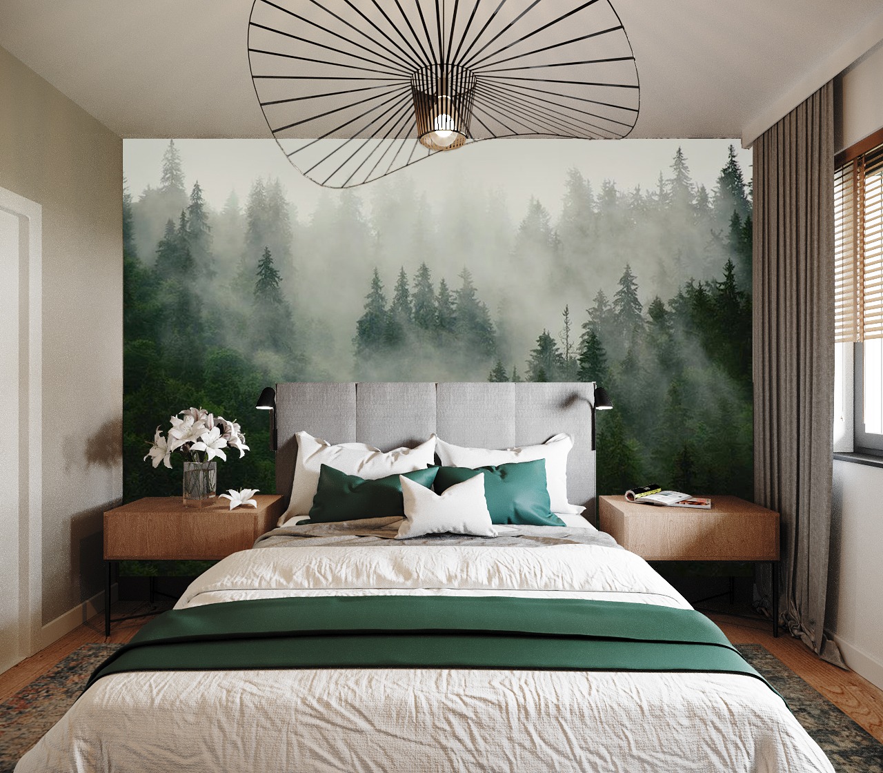 Sypialnia z łóżkiem, szarą tapicerowaną ramą, zielonymi poduszkami i narzutą, fototapetą z motywem mglistego lasu, drewnianymi szafkami nocnymi i designerską lampą sufitową.