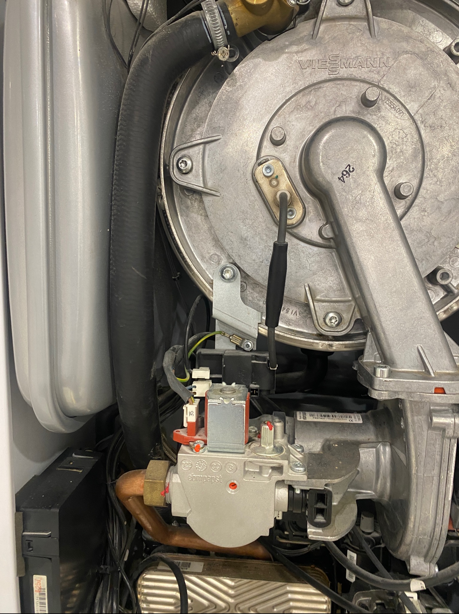 Wnętrze kotła gazowego Viessmann z widocznymi elementami palnika, przewodami i elektroniką, ukazujące detale konstrukcyjne.